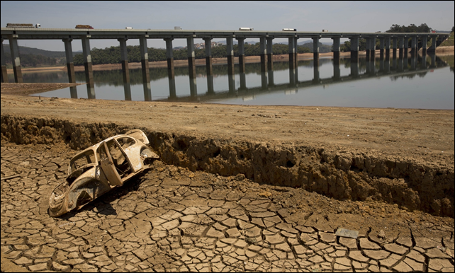 The frame of a car on the cracked earth at the bottom of the Atibainha dam, part of the Cantareira system near S&atilde;o Paulo, Brazil, in October 2014. Photo: Andre Penner / AP