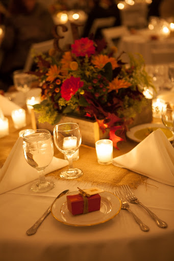 Our florist used the same reclaimed pallet wood for centerpiece flower boxes, and each seasonal arrangement was slightly different. The wooden numbers also came from Etsy. And the wrapped chocolate favors with wooden nametags served as both placecards and favors.