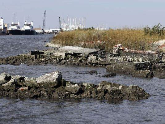 In this December 2012 photo, water washes around the tombs of those buried in a cemetery in Leeville in south Louisiana. What's left of the old Leeville cemetery is only accessible by boat. Photo: Dave Martin / AP