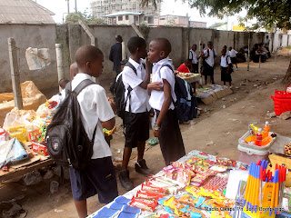 Quelques élèves du collège Boboto observent les articles étalés par les détaillants, le long de la clôture de leur école le 5/9/2011 à Kinshasa, à l'occasion de la rentrée scolaire 2011-2012. Radio Okapi/ Ph. John Bompengo