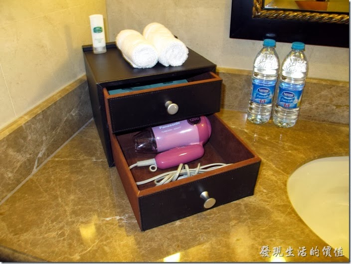 上海-齊魯萬怡大酒店。客房的浴室內有兩瓶雀巢的礦泉水，吹風機與盥洗用品都有。