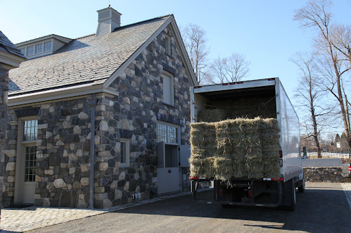Ok, the driver is pulling up by the stable.  From the looks of things, it's really a good thing that we have that conveyor!
