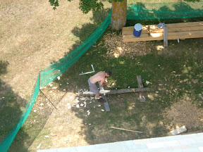 Seth Kelley is seen from the bell deck adzing out one of the new hip rafters.