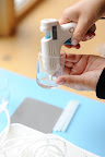 Step 3: While the wax is melting, place a small dot of hot glue at the middle bottom of your candleholder, and adhere the wick.