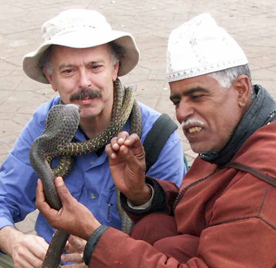 Richard Muller and snake charmer. The 'charmer' teased the cobra with his fingers and his tongue, and the cobra repeatedly struck. But the man was faster. Note how he holds the cobra. He can sense when it is going to strike, and it can only strike a short distance. muller.lbl.gov