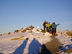 Climbers coming down with moon behind.