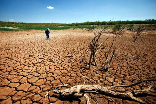 Coke County Extension Agent, Garrett Gilliam, walks through a sun-scorched cracked lake bed where Lake E.V. Spence was once 30 feet deep. 'The morale is to survive,' Gilliam said. 'The good times will come again and we just keep praying to the good Lord that he'll bless us.' Michael Paulsen / Houston Chronicle