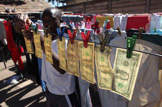 Alex Mupondi, hangs one dollar notes on a drying line after washing them in Harare, Zimbabwe, Tuesday, July 6, 2010. The washing machine cycle takes about 45 minutes _ and George Washington comes out much cleaner than before in Zimbabwe-style laundering of dirty money. Zimbabweans trading in the American currency since their own hyperinflationary notes were abandoned last year say washing their dirtiest cash works.(AP Photo/Tsvangirayi Mukwazhi)