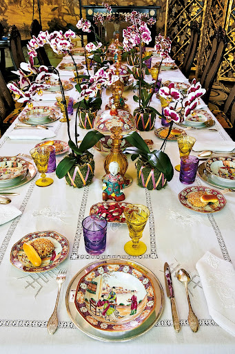 Orchids glorify the color mauve as they are nestled in moss, laced with ribbons, and lined down the sides of this table. Orchids glorify the color mauve as they are nestled in moss, laced with ribbons, and lined down the sides of this table.