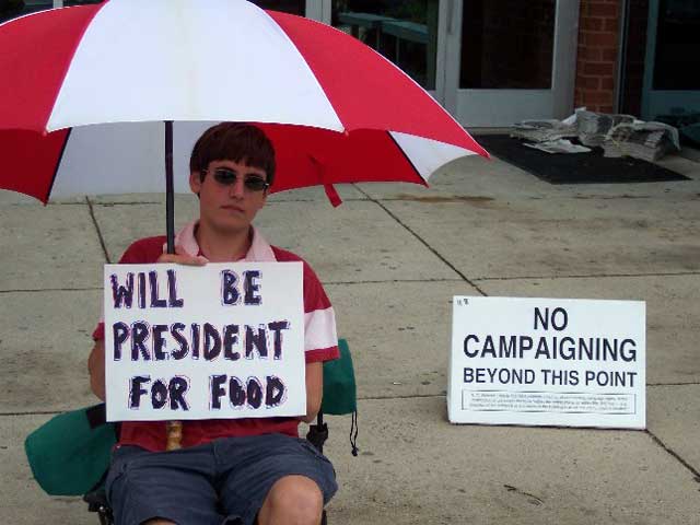 Boy holding sign 'Will Be President For Food'