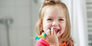 Small girl washing her teeth