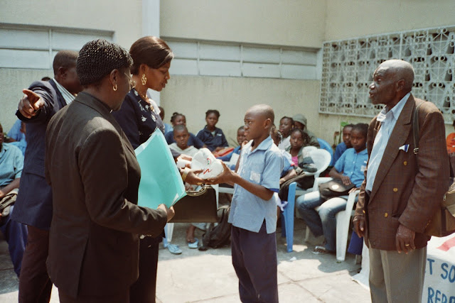 015_16.jpg - Madame Kinata, première secrétaire d'Ambassade de Brazzaville à Kinshasa remet un ballon à l'élève, don de l'association l'oeil de l'enfant.