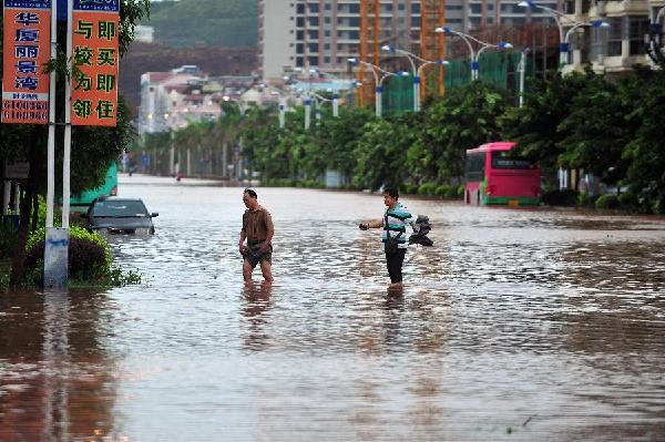 Two citizens wade through a waterlogged road in Fangchenggang City, south China's Guangxi Zhuang Autonomous Region, 18 August 2012. Typhoon Kai-Tak has affected about 1.26 million people and 134,470 hectares of farmlands in Guangxi till 4:30 p.m. Saturday. Local flood control authority initiated a Level IV emergency response to cope with the possible flooding. Xinhua / Huang Xiaobang