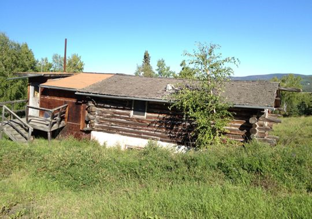 Ruth Macchione's old home in Fairbanks, Alaska, shown here on 26 August 2013, is sinking into the ground. Her late husband hand-built it with sturdy logs, but the house rests on permafrost -- the top layer of which freezes and thaws each year -- so it's now tilted. Photo: Wendy Koch / USA TODAY