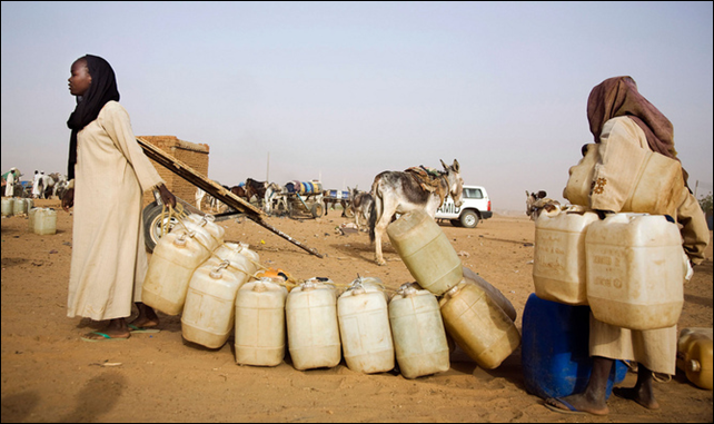 Abu Shouk: Water point in Abu Shouk IDP Camp, 12 May 2010. 84.000 people collect water everyday from the only water point in the area. Each family has the right to collect water twice per week with at most 15 contaners of 8 liters each. They pay for 10 contaners, and they get the other 5 for free. In the morning, mothers and children spend hours on the queue and, then, after filling the contaners, they bring them to their homes (some kilometers away) usually by donkeys or just walking. Photo: Albert Gonzalez Farran / UNAMID