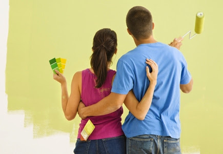Large kitchen with green paint on walls, wood cabinets and floors, white doors and trim.