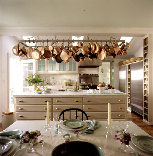 Martha likes to hang her pots and pans from hooks on an overhang. This frees up storage space in her kitchen while also adding a chandelier-like element to the room.