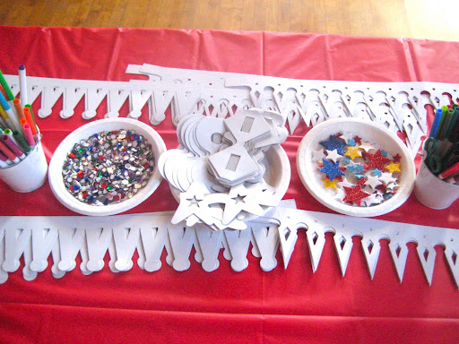 One of the craft tables with paper crowns, paper glasses....