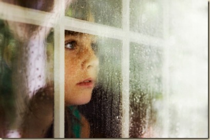 boy-looking-out-window-in-the-rain