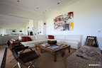 El sillón en forma de L propone un lugar confortable para disfrutar de la gran pantalla, mientras que dos petacas antiguas bolivianas hacen las veces de mesa. Los sillones de gamuza marrón de Mar Abierto aportan un toque cálido. Sobre la pared, un cuadro de la propia María Emilia Lobbosco. Gentileza: Revista D&D.