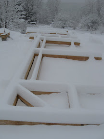 An unexpected snowfall covers the first assembled bent.
