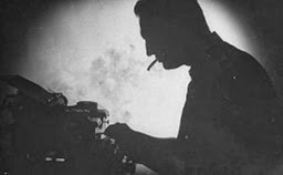 c0 A writer in silhouette at his typewriter