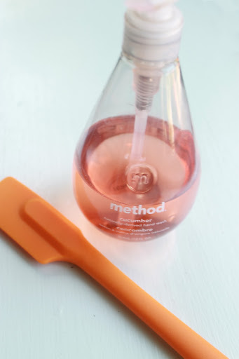 Pink hand soap and an orange spatula