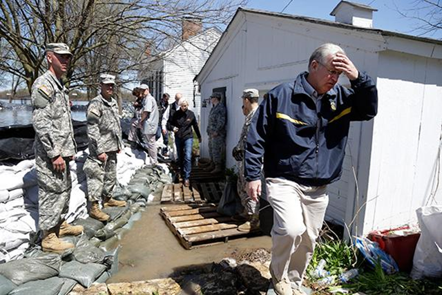 Missouri Gov. Jay Nixon, right, walks away from floodwaters after meeting with members of the Missouri National Guard as they make flood preparations on 20 April 2013 in Clarksville. Communities along the Mississippi River and other rain-engorged waterways are waging feverish bids to hold back floodwaters that may soon approach record levels. Photo: Jeff Roberson / The Associated Press