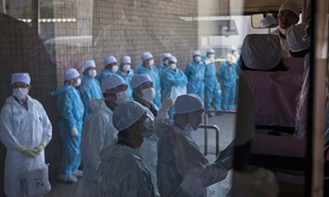 Tepco employees wait for a bus at J Village, a football training complex now serving as an operation base for those battling Japan's nuclear disaster. Photo: Reuters