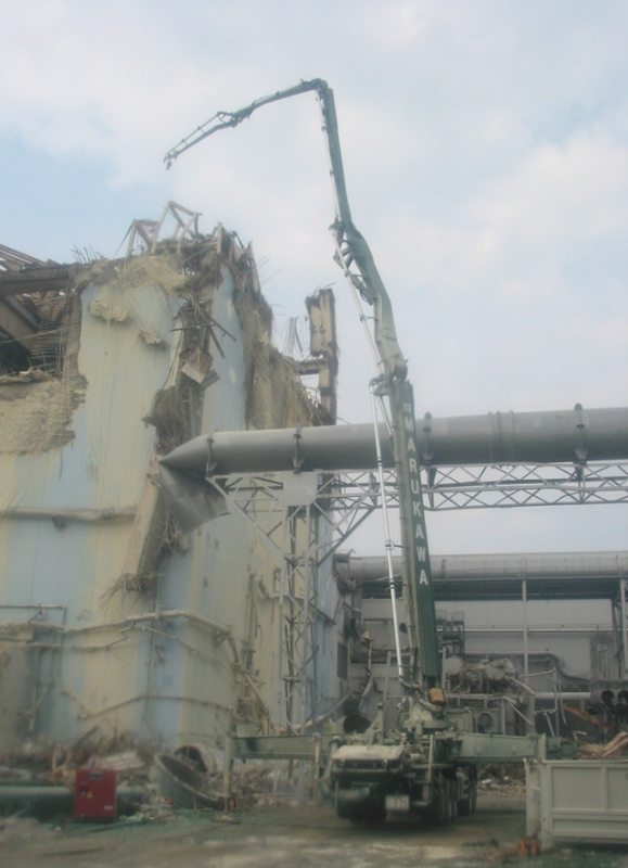 Workers use a concrete boom to sample airborne radioactive substances at the upper part of reactor building, Unit 3, Fukushima Daiichi Nuclear Power Station, 13 June 2011. TEPCO