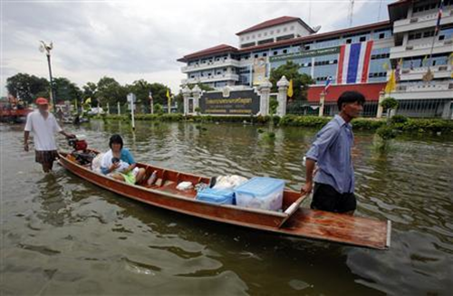 A woman holds her baby as they are evacuated from a hospital in flooded area of Thailand's Ayutthaya province October 9, 2011. Chaiwat Subprasom / REUTERS