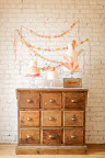 An old chest of drawers and festive garland beautifully display the cake.