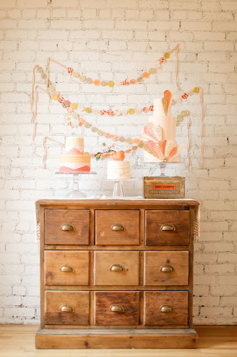 An old chest of drawers and festive garland beautifully display the cake.