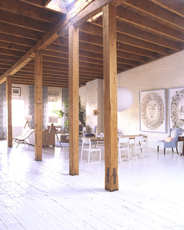 The pine floors and brick walls of this loft were coated with white paint to brighten a space dominated by wooden columns and beams that are original to the structure.
