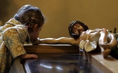 c0 A litte girl kissing the hand of the crucified Jesus