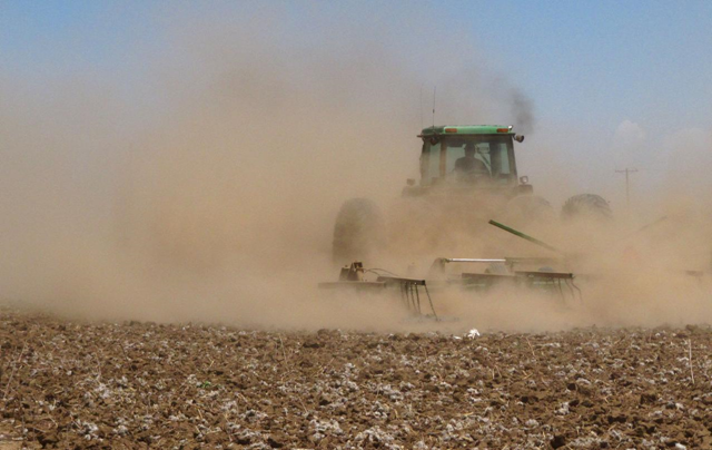 In this May 19, 2011 photo, Tyler Gray stirs up a cloud of dust as pulls a tiller across a dry cotton field near Lubbock, Texas, trying to break up hardened ground. A historic drought has already cost Texas farmers and ranchers an estimated $1.5 billion, and the cost is growing daily as parched conditions persist in much of the state. AP Photo / Betsy Blaney