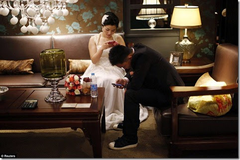 A couple waits to participate in a staged mass wedding, organised as part of a matchmaking event to inspire singles to get married, in a suburban area of Shanghai May 18 A couple waits to participate in a staged mass wedding, organised as part of a matchmaking event to inspire singles to get married, in a suburban area of Shanghai May 18