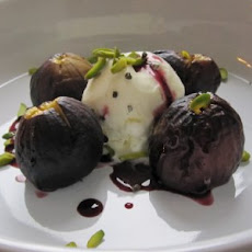 Roasted figs in a red wine cardamom-infused reduction with vanilla ice cream