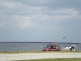 Some kite-sufers have a fun time in the water on this windy day.