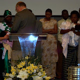 Pastor John and Han praying over Andrew's family