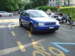 Contresens cyclable, rue de Beaumont. Le cycliste qui doit éviter cette voiture s’expose dangereusement au trafic venant de face.