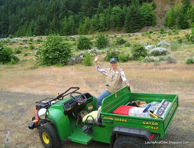 Laurie in volunteer vest and hat, ready to pilot the Gator.