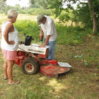 George uses Owen's mow as a tool bench to drill holes in signs.