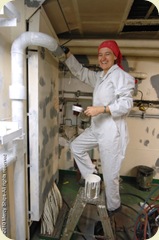 Crew member Gabriella painting in the engine room aboard the M/V Africa Mercy during shipyard phase in Durban, South Africa