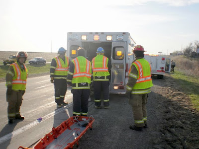 Emergency personnel help load an injured male into the ambulance