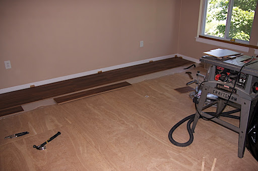 Beginning to put down the hardwood laminate flooring.