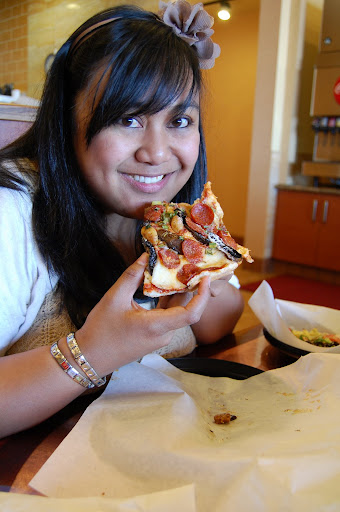 Trying to chew pizza and smile at the same time.