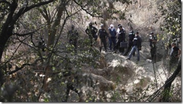 State police guard the site where at least five bodies were found in a clandestine grave in Santa Mara Tlalmanalco on the outskirts of Mexico City