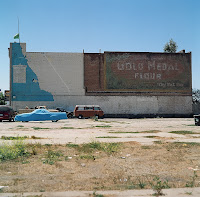 Date: Spring 2006
Location: Guadaloupe, California, Route 1

The drive from San Francisco to San Diego product a bevy of nice pictures.

We came across this town that looked like it came out of a cowboy film. We turned a corner and here was this town, one street, a bunch of buildings, some parked cars. We were waiting for the horses to make their entrance. We drove by this wall, and were half way down the road when I decided to go back and take the picture. It was just too tempting.

The juxtaposition of the colours on the wall with the colours of the cars. Too hard to resist.