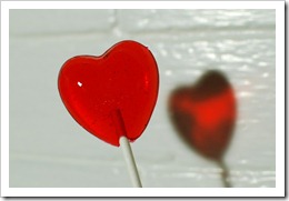 red heart-shaped cinnamon-cherry lollipop photographed from the front